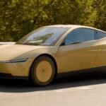 Tesla Cybercab dourado na estrada, visto de frente